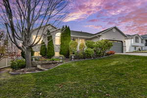 Single story home featuring a front lawn, stucco siding, concrete driveway, and a garage