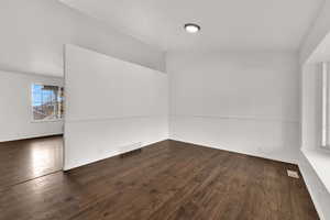 Empty room featuring dark wood finished floors
