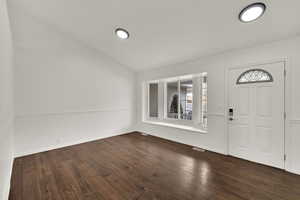 Entryway featuring lofted ceiling and dark wood-type flooring