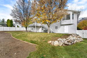 Rear view of house featuring a wooden deck and stairway