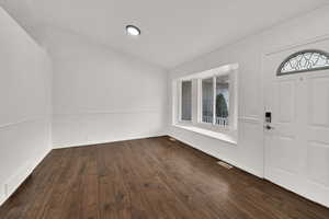 Entrance foyer featuring dark wood finished floors and vaulted ceiling
