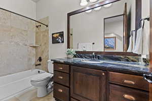 Bathroom with vanity, shower / bath combination, and light tile patterned floors