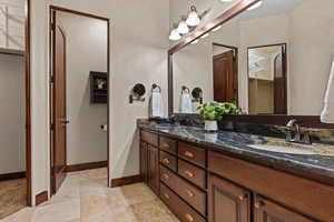Bathroom with double vanity and light tile patterned floors