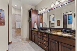 Full bath featuring double vanity and a walk in shower