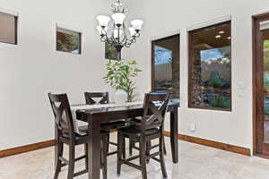 Dining area featuring baseboards and a chandelier