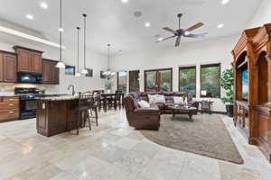 Living area featuring recessed lighting, a chandelier, a ceiling fan, and a high ceiling