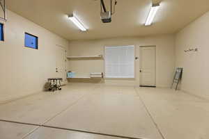 Garage featuring a garage door opener and baseboards