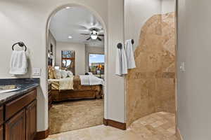 Full bathroom featuring connected bathroom, vanity, tiled shower, a ceiling fan, and recessed lighting