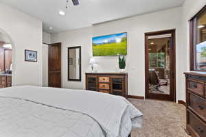 Bedroom with carpet floors, arched walkways, ceiling fan, recessed lighting, and access to outside