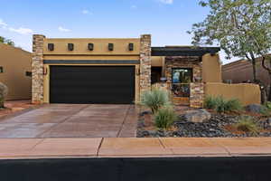 View of front of home with driveway, stucco siding, a garage, and a fenced front yard