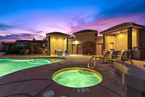 Pool at dusk featuring a community hot tub, ceiling fan, and a patio