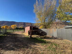 Fenced backyard featuring a mountain view and an outbuilding