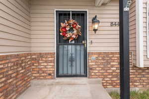 View of exterior entry with brick siding