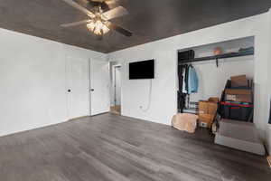 Master Bedroom with wood finished floors, ceiling fan, and a closet