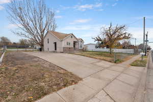 View of home's exterior with concrete driveway and fenced front yard