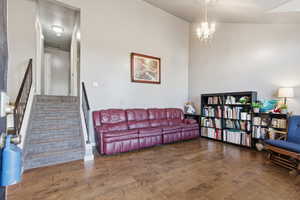 Living area with wood finished floors, stairs, and a chandelier
