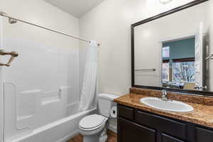 Full bathroom with connected bathroom, shower / bath combo, vanity, and dark wood finished floors