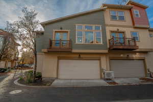 View of front of home with a balcony, french doors, and stucco siding