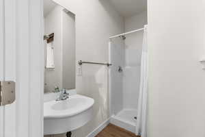 Full bathroom featuring a shower stall and dark wood finished floors