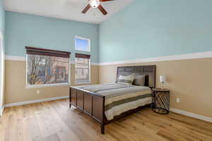 Bedroom with high vaulted ceiling, light wood-type flooring, and a ceiling fan