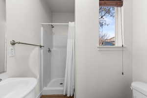 Full bathroom with a shower stall and dark wood finished floors