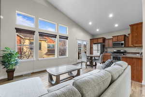 Living area featuring recessed lighting, light wood finished floors, and high vaulted ceiling
