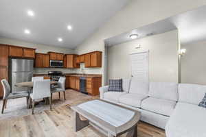 Living room featuring light wood finished floors, recessed lighting, and high vaulted ceiling