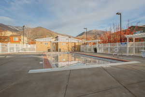 Community pool featuring a mountain view, a pergola, and a patio