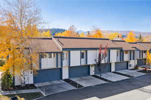 Traditional-style home with concrete driveway, a shingled roof, a garage, a mountain view, and a residential view