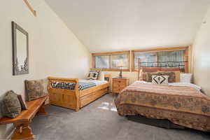 Carpeted bedroom featuring lofted ceiling and a textured ceiling