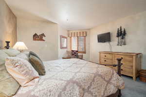 Bedroom featuring carpet and a textured ceiling