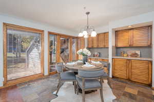 Dining area featuring a chandelier and dark stone finish floors