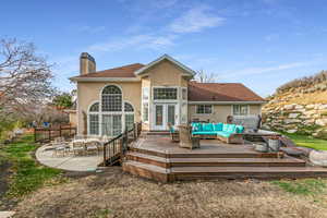 Back of property featuring an outdoor hangout area, stucco siding, a chimney, a deck, and roof with shingles