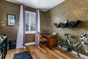 Home office with light wood-type flooring and baseboards