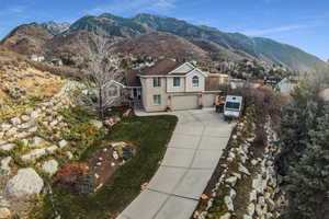 View of front of property featuring a mountain view, driveway, an attached garage, and stucco siding