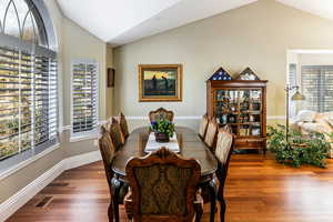 Dining space featuring vaulted ceiling and wood finished floors