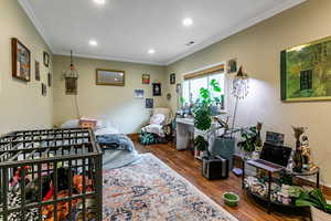 Bedroom with crown molding, dark wood finished floors, and recessed lighting
