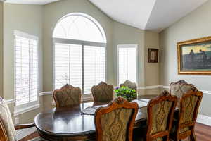 Dining space with dark wood-type flooring and lofted ceiling