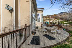 View of patio featuring outdoor dining area and a deck with mountain view