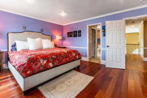 Bedroom featuring crown molding, dark wood finished floors, connected bathroom, and recessed lighting