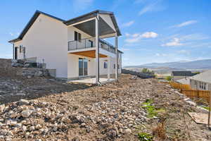 Back of property featuring a patio, a mountain view, and stucco siding