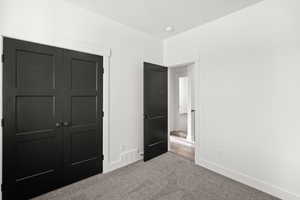 Unfurnished bedroom with a closet and carpet