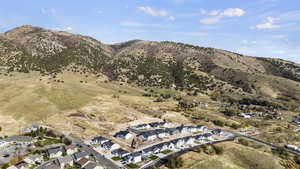Aerial view of property and surrounding area featuring nearby suburban area and mountains