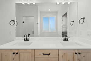 Bathroom with double vanity and a stall shower