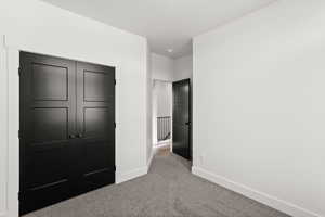 Unfurnished bedroom with carpet and a closet