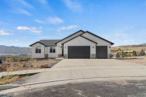 Modern farmhouse style home with a mountain view, concrete driveway, an attached garage, and stone siding