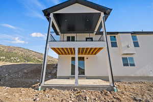 Back of house with a patio and a balcony
