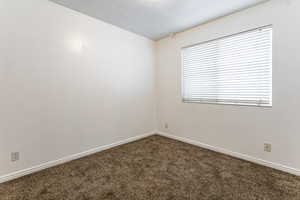 Empty room with carpet floors and baseboards