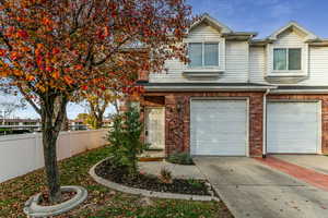 Traditional-style home with concrete driveway, an attached garage, and brick siding