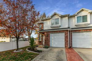 Traditional-style home with concrete driveway, brick siding, and a garage